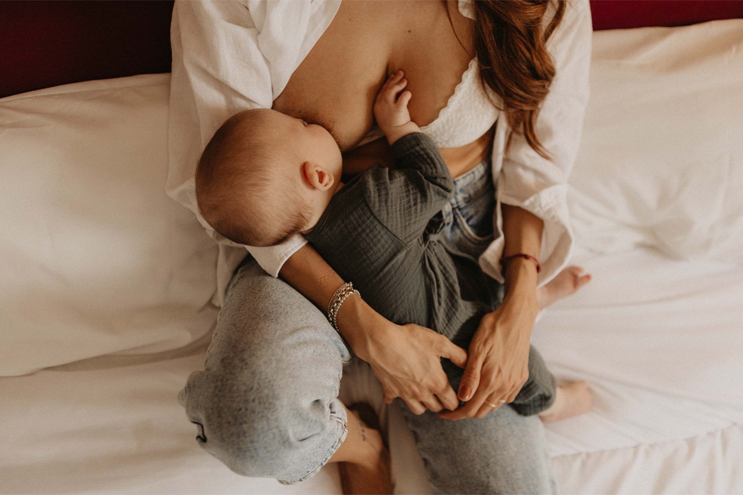 Fotografía de una madre con su bebé sobre la cama
